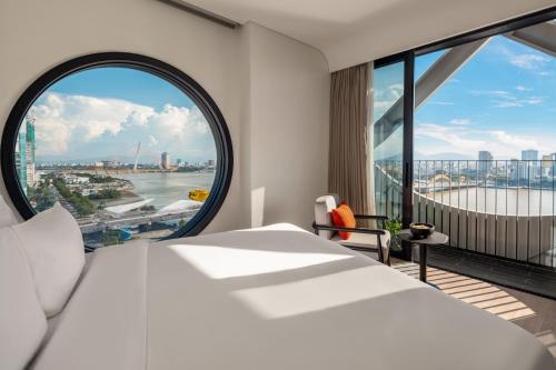 a bedroom with a large bed and a large window at Caro Premium Danang Hotel in Da Nang