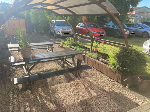 a picnic table under a canopy in a parking lot at Pod Różą B&B in Ustka