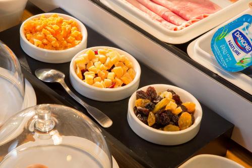 a buffet with bowls of food on a table at Hotel De France in Angerville