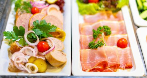 two white plates of food with different types of foods at Victor's Residenz-Hotel Gera in Gera