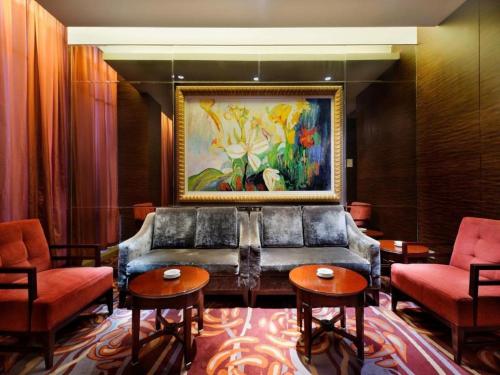 a living room with a couch and chairs and a painting at Putian Depo Hotel in Putian