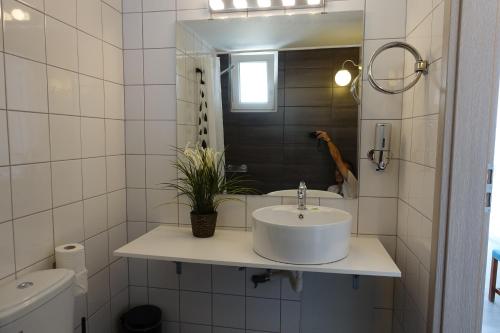 bagno bianco con lavandino e specchio di Hotel Rene a Città di Skiathos