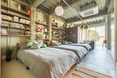 a row of beds in a room with bookshelves at TOKYO Beverly Hills,Exclusive Lifestayle,SHIUYA,SHINJUKU,ART,Bespoke ApartmentSEIJO in Waizumi