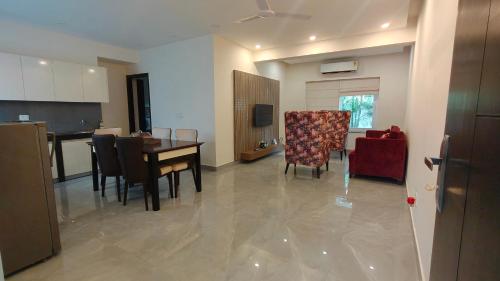 a kitchen and dining room with a table and chairs at Lavish Apartments with Pool Candolim Luxfort in Candolim