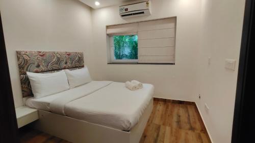 a small bedroom with a bed and a window at Lavish Apartments with Pool Candolim Luxfort in Candolim