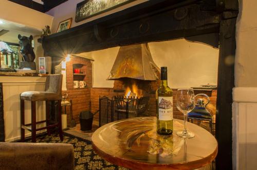 a table with a bottle of wine and two glasses at The Bell Inn in Newmarket