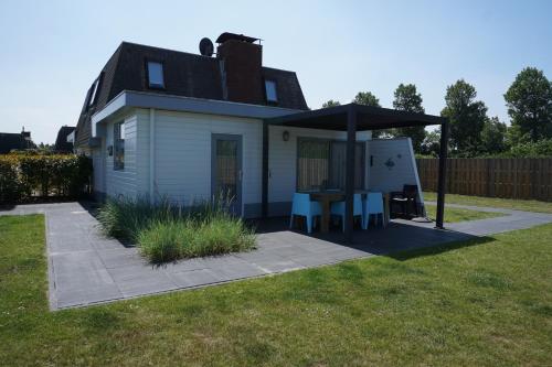 a house with a table and a gazebo at Kustverhuur, Park Schoneveld, Zeester 46 in Breskens