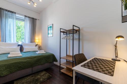 a bedroom with a bed and a table and a desk at Zentral gelegenes 3 BR Work&Soul Apartment, ideal zum Entspannen und Arbeiten in Neustadt an der Weinstraße