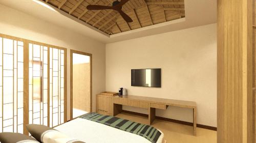 a bedroom with a desk and a tv on the wall at Chaweng Regent Beach Resort in Chaweng