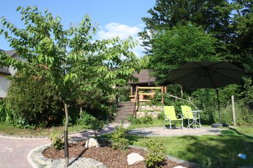 a patio with an umbrella and a table and chairs at Apartament i Pokoje Gościnne u Lusi in Wisła