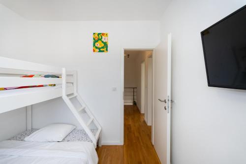 a bedroom with a bunk bed and a flat screen tv at Three Seas in Maslenica
