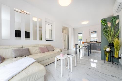 a white living room with a couch and a table at Three Seas in Maslenica