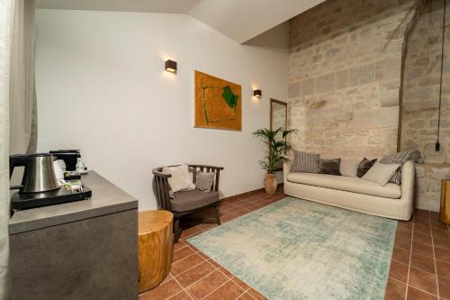 a living room with a couch and a chair at Heritage Hotel Maskovica Han in Pakoštane