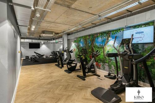 a gym with treadmills and ellipticals in a room at Penthouse Hackney Wick with Balcony, gym, rooftop in London