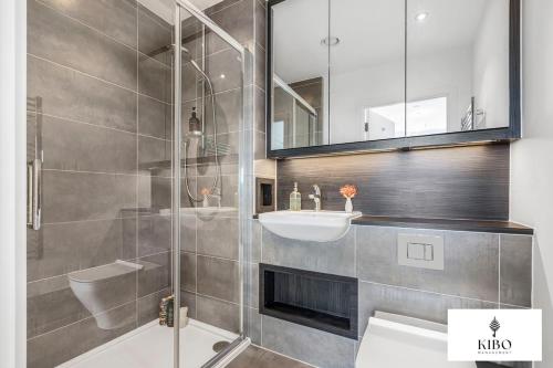 a bathroom with a shower and a sink and a mirror at Penthouse Hackney Wick with Balcony, gym, rooftop in London