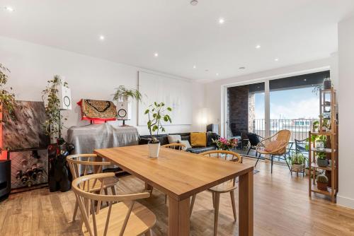 a living room with a wooden table and chairs at Penthouse Hackney Wick with Balcony, gym, rooftop in London