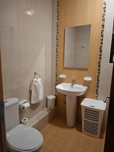 a small bathroom with a toilet and a sink at Spacious Bugibba Seafront Home 3BR Free Parking Free WiFi in St. Paul's Bay