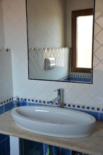 ブドーニにあるMelania Tanaunellaのバスルーム(鏡付きの大きな白いバスタブ付)