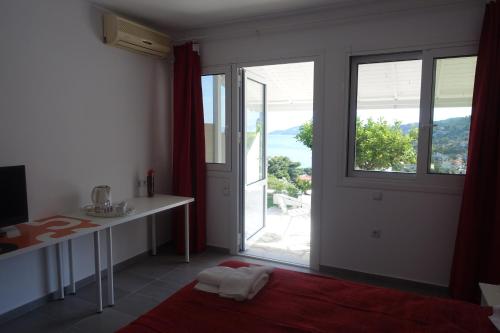 a room with a table and a large window at Hotel Rene in Skiathos Town