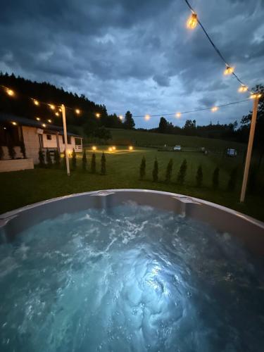 a hot tub in a backyard at night at Górna Kudowa Domki Wypoczynkowe z balią in Kudowa-Zdrój
