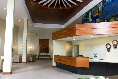 a lobby with a reception desk and a ceiling at Hotel Pousada do Bosque in Ponta Porã