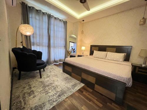 een slaapkamer met een groot bed en een stoel bij Luxury One Bedroom Apartments -Facing Centaurus Mall Islamabad in Dargai