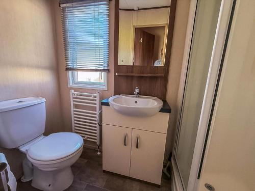 een kleine badkamer met toilet en wastafel bij Modern Caravan With Decking At Haven Hopton-On-Sea Ref 80032M in Great Yarmouth