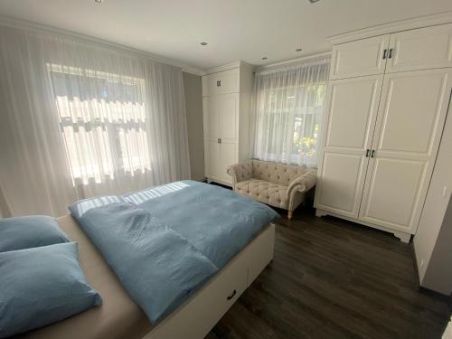 a bedroom with a bed and a couch and windows at AV ApartmenT in Rēzekne