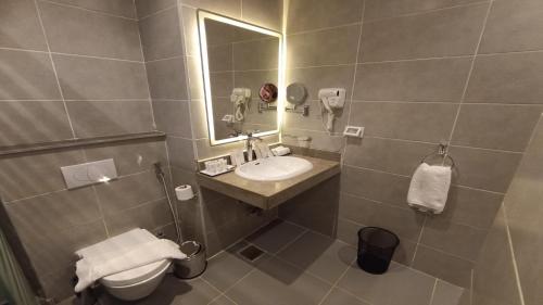 a bathroom with a sink and a toilet and a mirror at Jewel Plaza and Aqua Park in Cairo