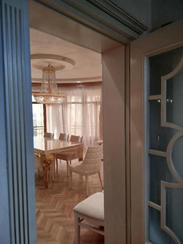 a dining room with a table and chairs and a chandelier at Baku Artpatena Lake view in Baku