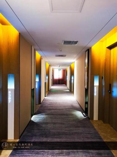 a hallway in a building with a long corridor at Yuan Culture Hotel Shenzhen World Shajing in Shenzhen