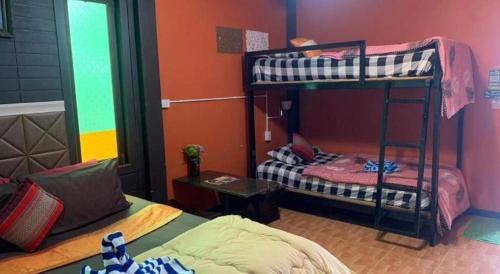 a room with two bunk beds and a bed at Wanghin Bungalow in Surat Thani