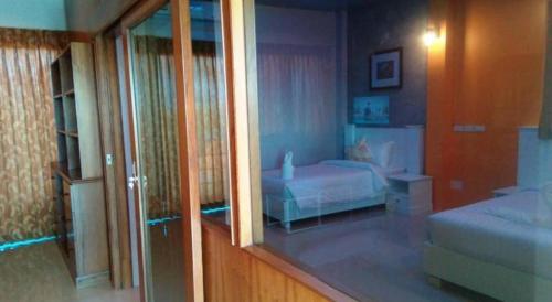 a room with a bedroom with a bed and a mirror at Waenpetch place Hotel in Ubon Ratchathani