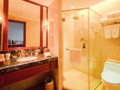 a bathroom with a shower and a sink and a toilet at King Century Hotel in Zhongshan