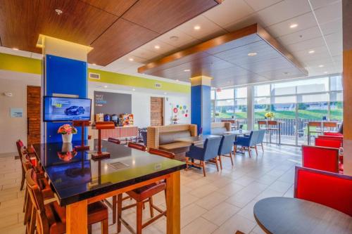 a restaurant with a dining room with tables and chairs at Holiday Inn Express & Suite Milroy - Reedsville By IHG in Burnham