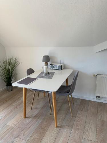 a white table with two chairs and a lamp on it at Ferienwohnung Wieben in Sankt Peter-Ording