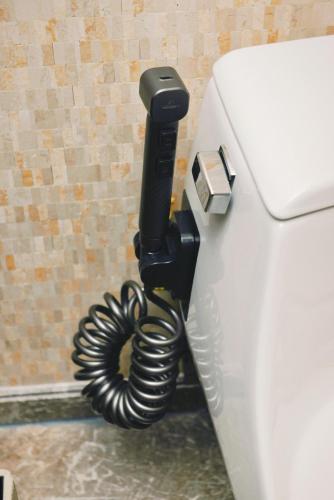 a phone is hanging on the side of a toilet at The Garden Hotel Guangzhou - Discover 26 cultural treasures with hotel Golden Tour Guide in Guangzhou