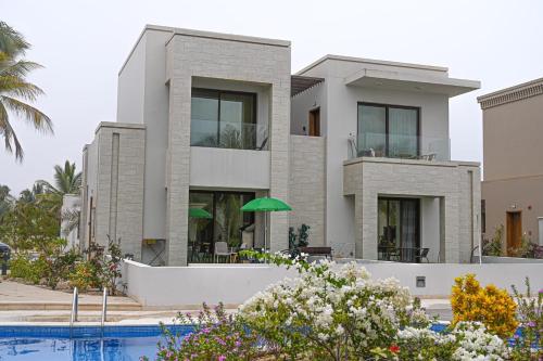 a house with a swimming pool in front of it at استيديو الهثيم هوانا صلاله in Ma‘mūrah
