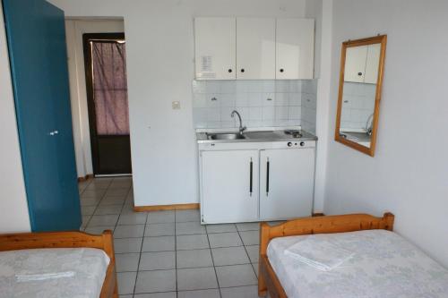 a kitchen with two beds and a sink and a counter at Villa Iris Studios in Ormos Panagias