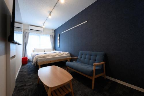 a room with two beds and a chair and a table at Rento Park Shiba 401 in Tokyo