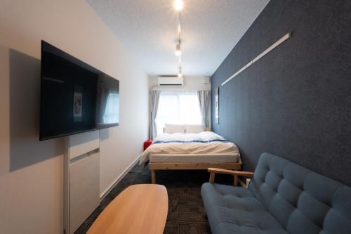 a small room with a couch and a bed at Rento Park Shiba 401 in Tokyo