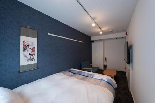 a bedroom with a bed and a blue wall at Rento Park Shiba 401 in Tokyo