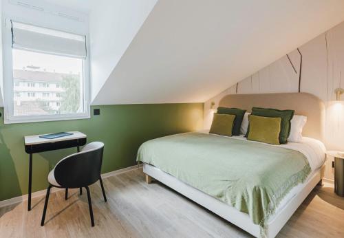 a bedroom with a bed and a chair and a window at Appart Hotel Neostelia in Annecy