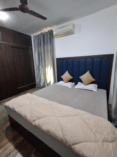 a bedroom with a large bed with a blue headboard at Premium apartment in Srinagar city center in Srinagar