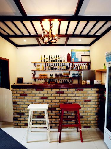 a bar with two stools and a brick wall at Moganshan Bamboo View Guesthouse in Deqing
