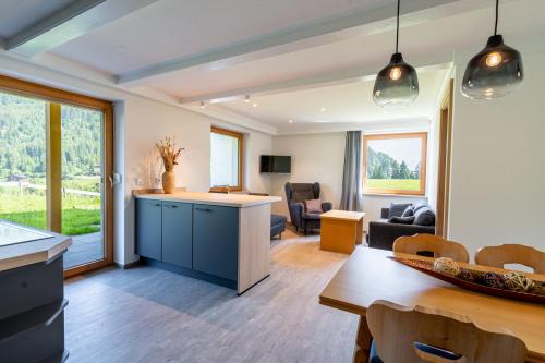 a kitchen and living room with a table and chairs at Gästehaus Strasser in Riezlern