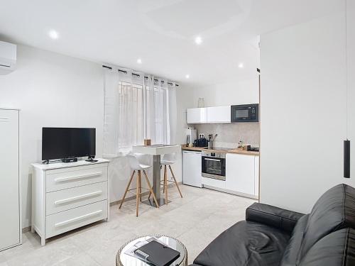 un salon avec un canapé et une cuisine dans l'établissement Studio Cosy Viel Antibes, à Antibes