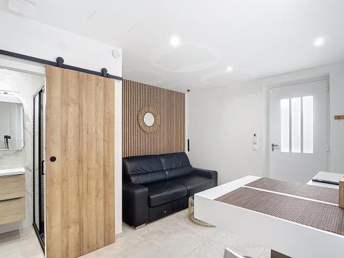 - une chambre avec un lit et un fauteuil en cuir noir dans l'établissement Studio Cosy Viel Antibes, à Antibes