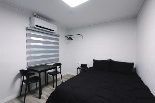a bedroom with a bed and a table and chairs at 부천 인생호텔 in Bucheon
