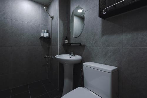 a bathroom with a sink and a toilet and a mirror at 부천 인생호텔 in Bucheon